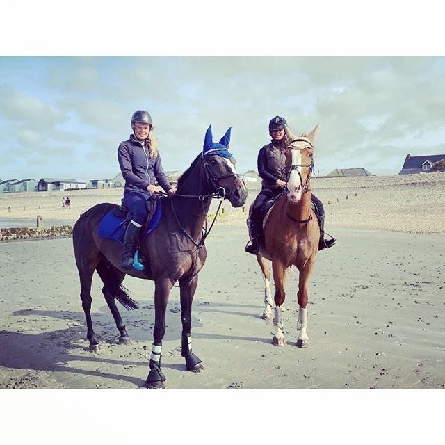 Image of a 2 riders on horses on a beach